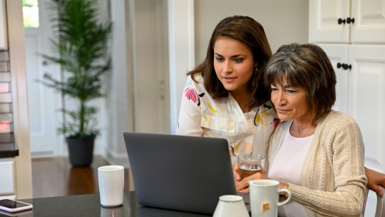 Mom and adult daughter using a laptop