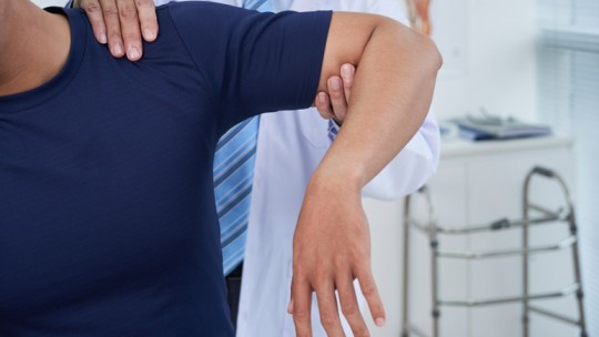 Physician checking shoulder injury
