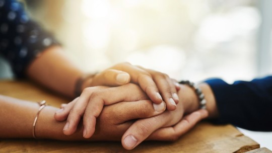 Two people with hands held together