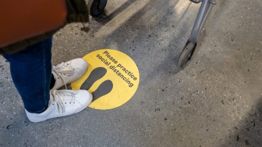 please practice social distancing sticker on ground