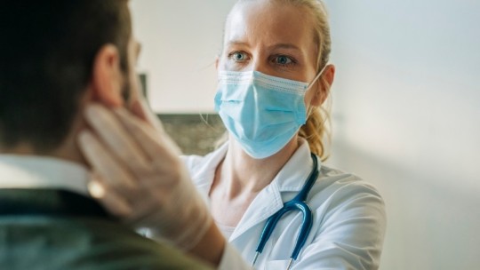 doctor wearing mask giving patient exam