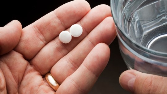 hands holding aspirin