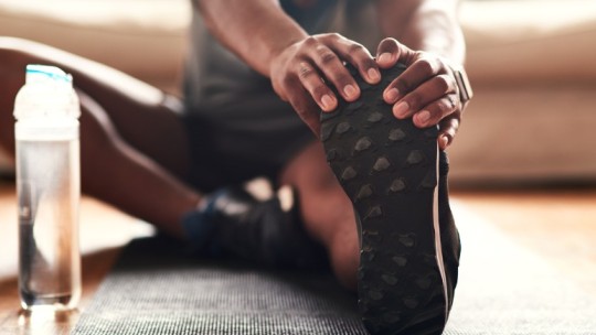 man stretching at home in living room