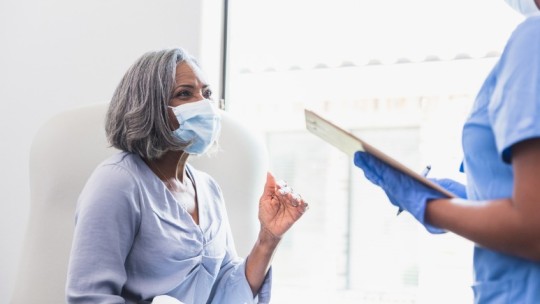 woman speaking with doctor in masks