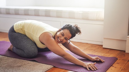 woman stretching lower back at home