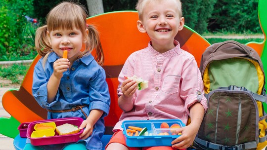 smiling kids with packed lunches