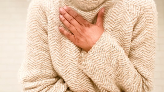 Woman holding hand over lungs
