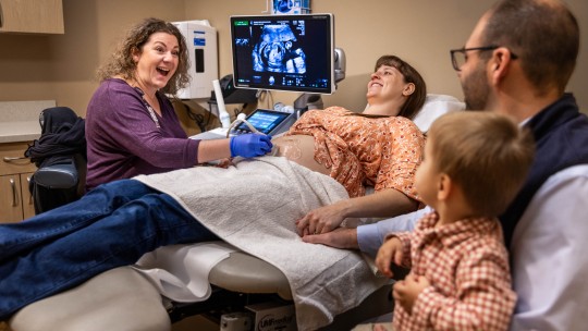 woman getting an ultrasound with her family