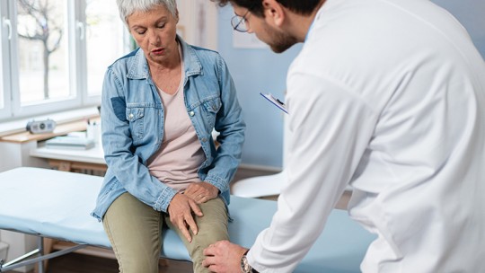 Doctor examining woman's knee