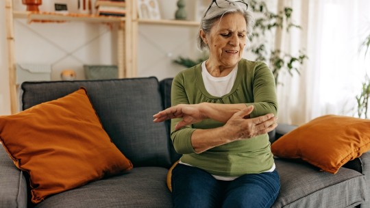 A senior woman holding her arm in pain