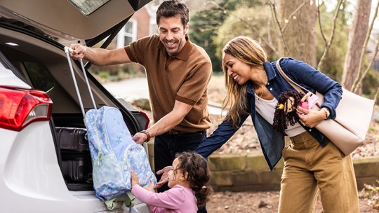 Young family packing the car to go on vacation