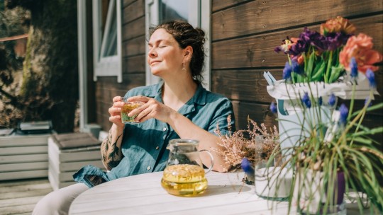 Woman drinking a cup of herbal tea outside on a patio