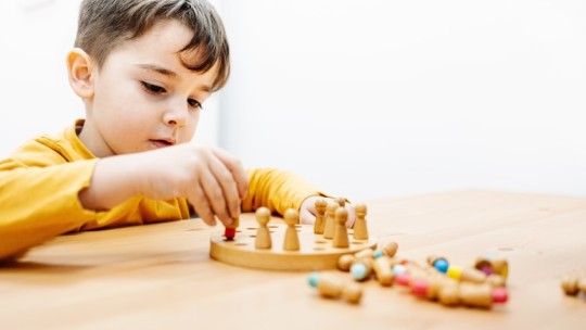Young child engaged in quiet play with a board game