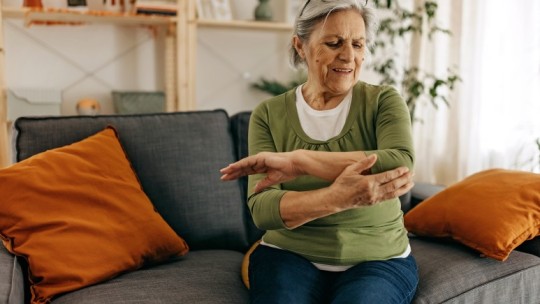 Senior woman rubbing painful elbow
