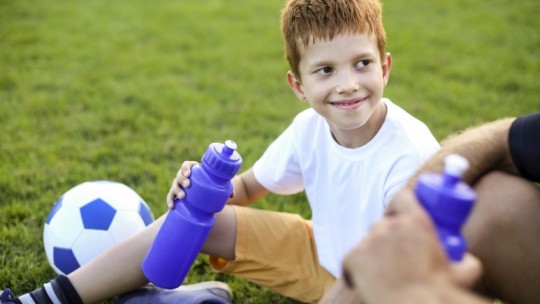 Young athlete taking a water break on the field