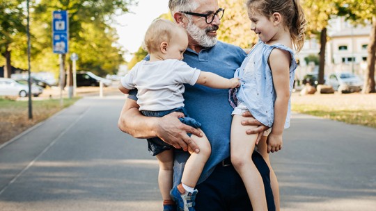 Older man holding his grandkids