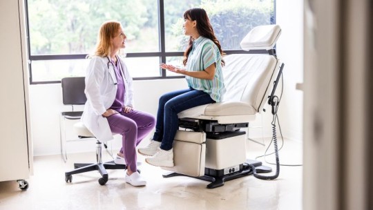 Primary care physician and a patient have a conversation in an exam room