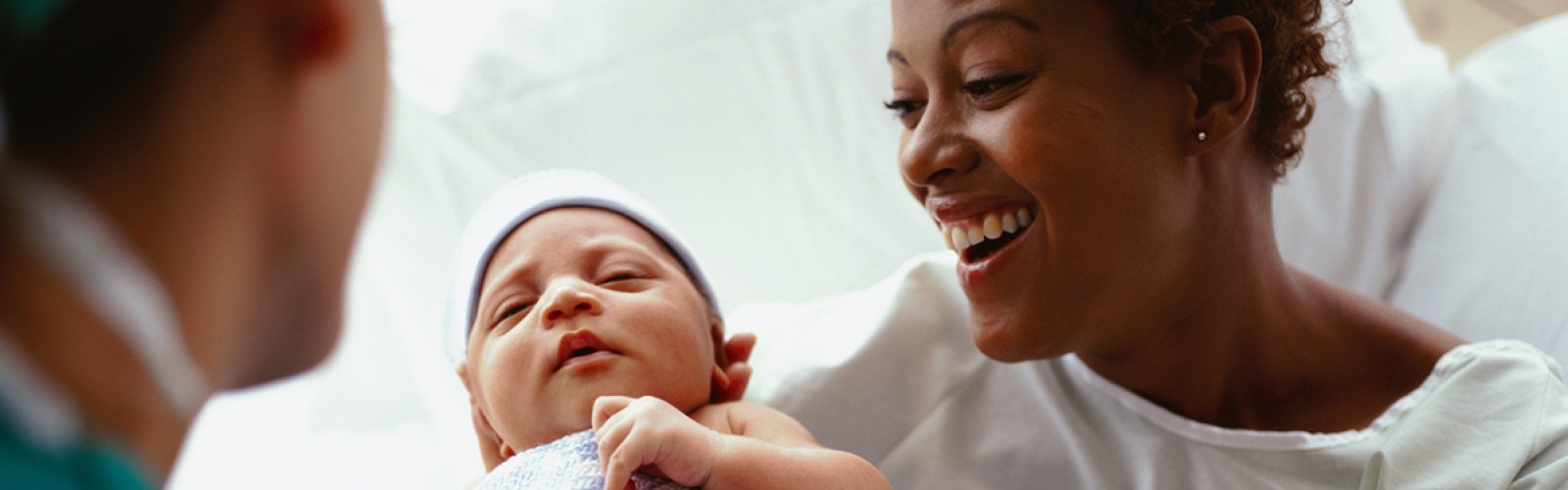 Mom holding new baby in hospital bed