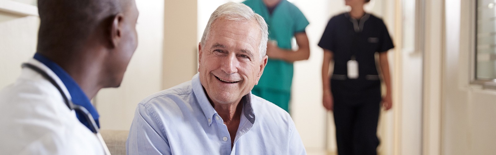 Older man speaking with doctor in hospital