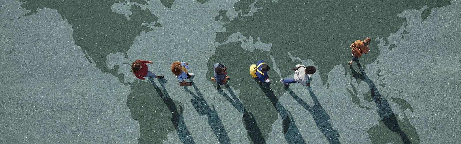 People walking across illustration of the world