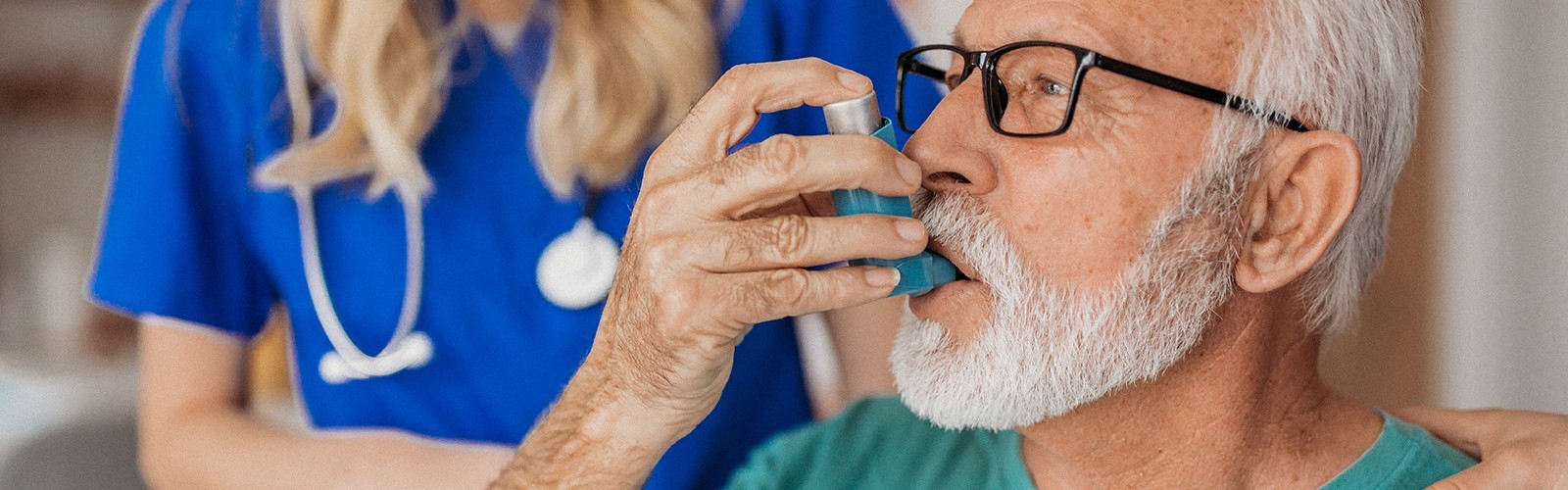 Older man using an inhaler