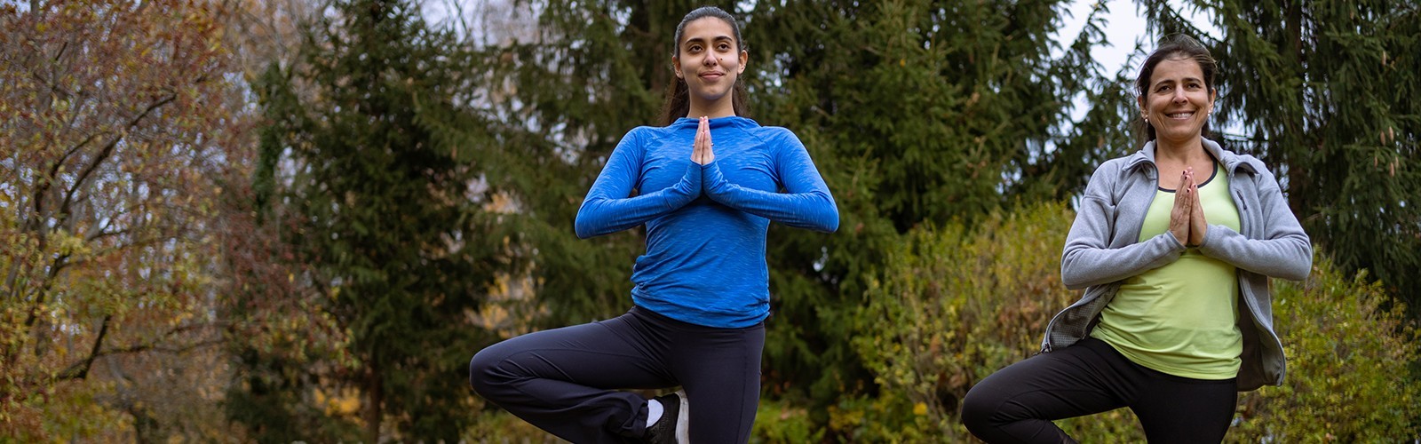 Mom and daughter doing yoga outside