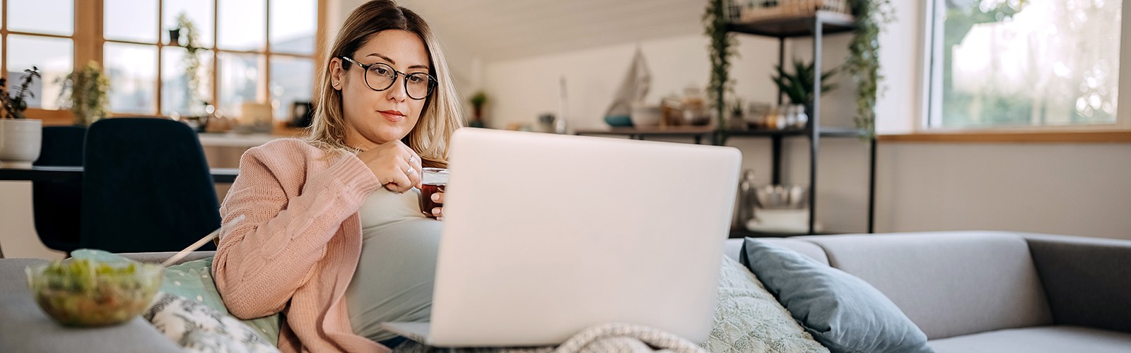 Pregnant woman at home using laptop