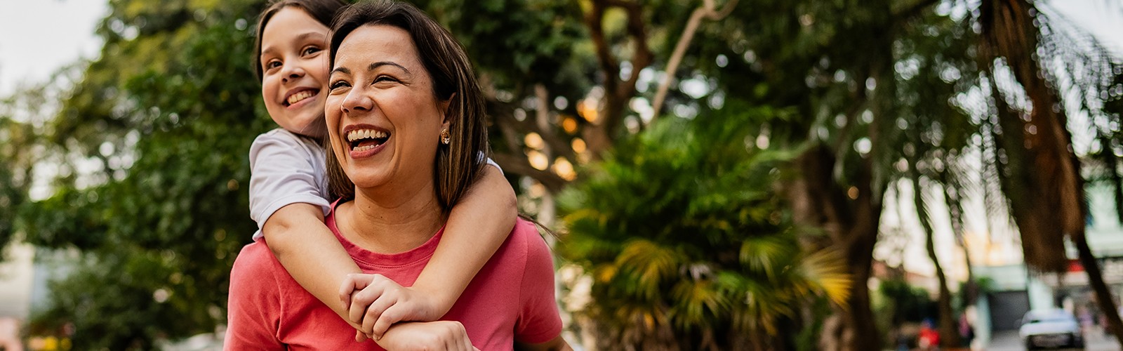 Happy mom giving daughter a piggyback ride