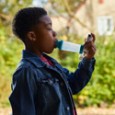 Young boy using asthma inhaler