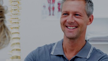 Osteopathic doctor teaching patient about spine