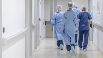 Group of surgeons walking down a hospital hallway
