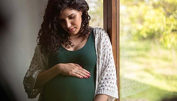 Pregnant woman standing by window