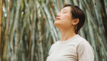 Relaxed woman by bamboo