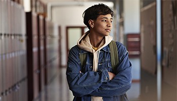 Adolescent standing in a school hallway