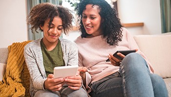 Mom and pre-teen watching a tablet