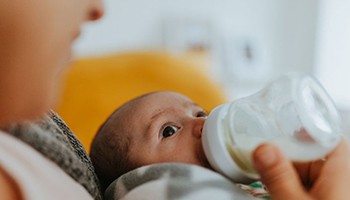 Newborn baby drinking from a bottle