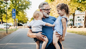 Older man holding grandkids